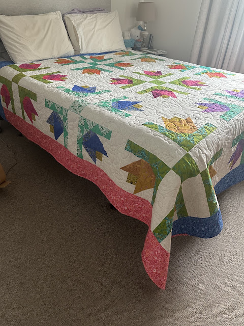 Hope BlooMS quilt large petal flowers with white background on queen size bed