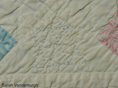 blue stitched Centennial star on quilt Centennial star stitched in blue on quilt