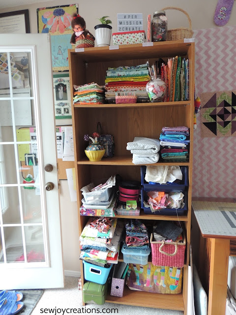 sewing room bookcase reorganized organized quilt room bookcase fabric display