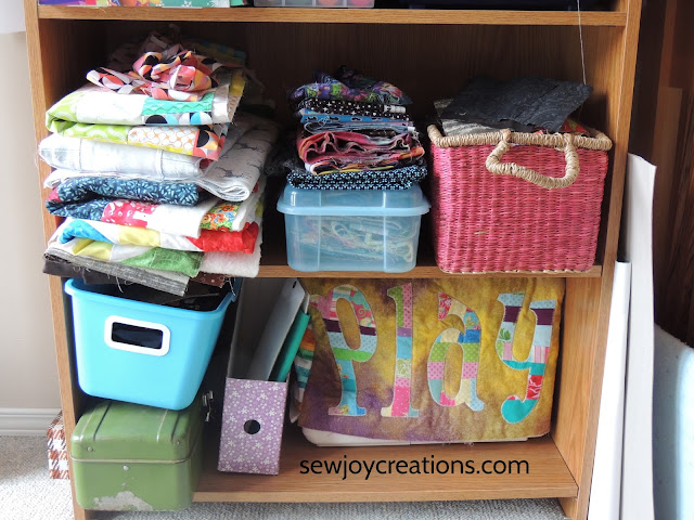 bottom shelves with quilt tops and sewing machine sewing machine cover project bins