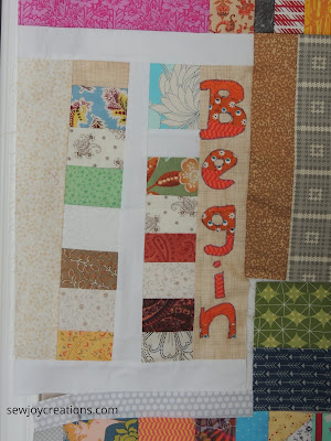 begin stitched onto a mini quilt machine stitched word on quilt