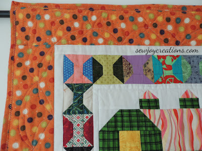 The curvy quilting in the border gives you something more to enjoy on closer viewing closeup of corner quilting on Quilty Barns quilt