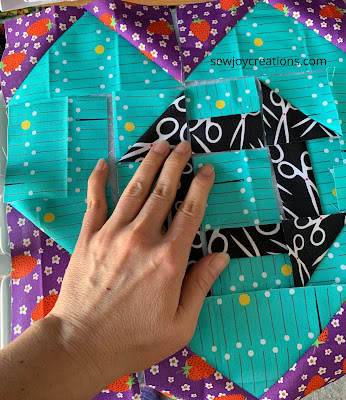 quilter hand on top of pieces for quilt block